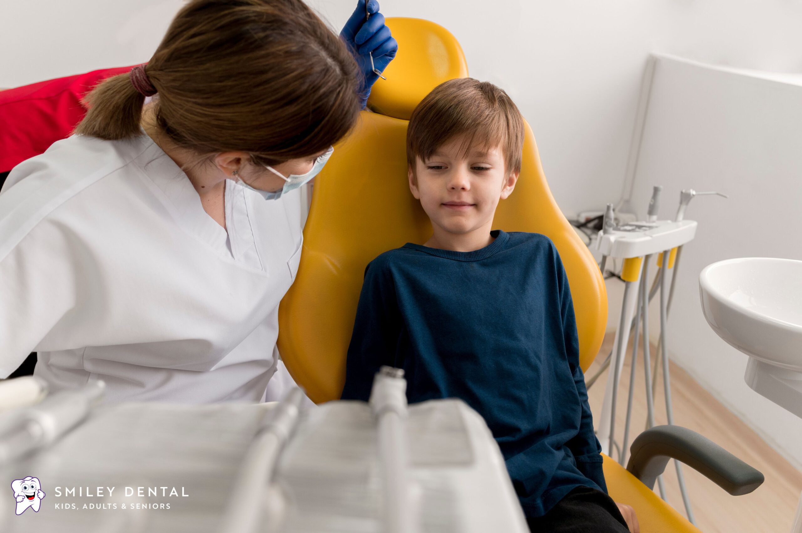 Young boy sitting calmly in a dental chair during a checkup with his dentist