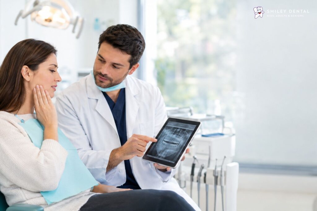 Dentist reviewing a dental X-ray with a patient who has tooth pain during an urgent dental visit