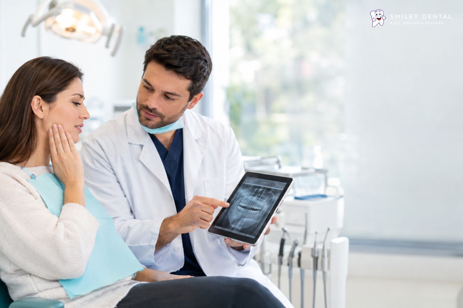 Dentist reviewing a dental X-ray with a patient who has tooth pain during an urgent dental visit